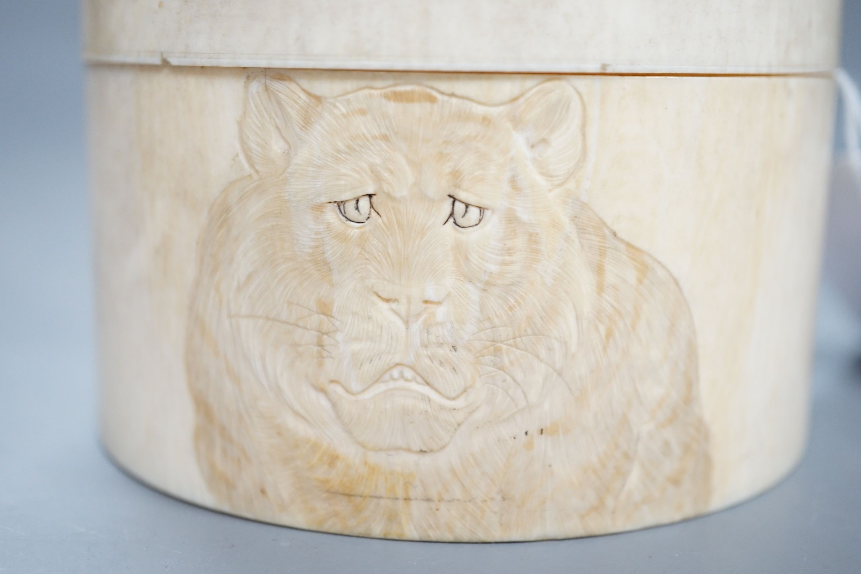 A Japanese ivory box and cover, Meiji period, carved with tigers, 9.2cm